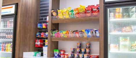 A snack and beverage display in a store with various snacks and drinks on shelves.
