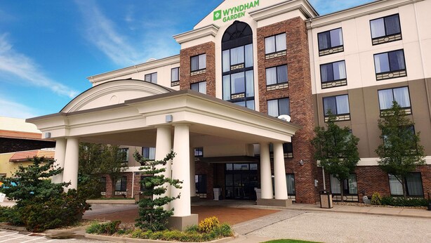 A Wyndham Garden hotel with a covered entrance, brick facade, and multiple windows. - Wyndham Garden Erie (Erie)