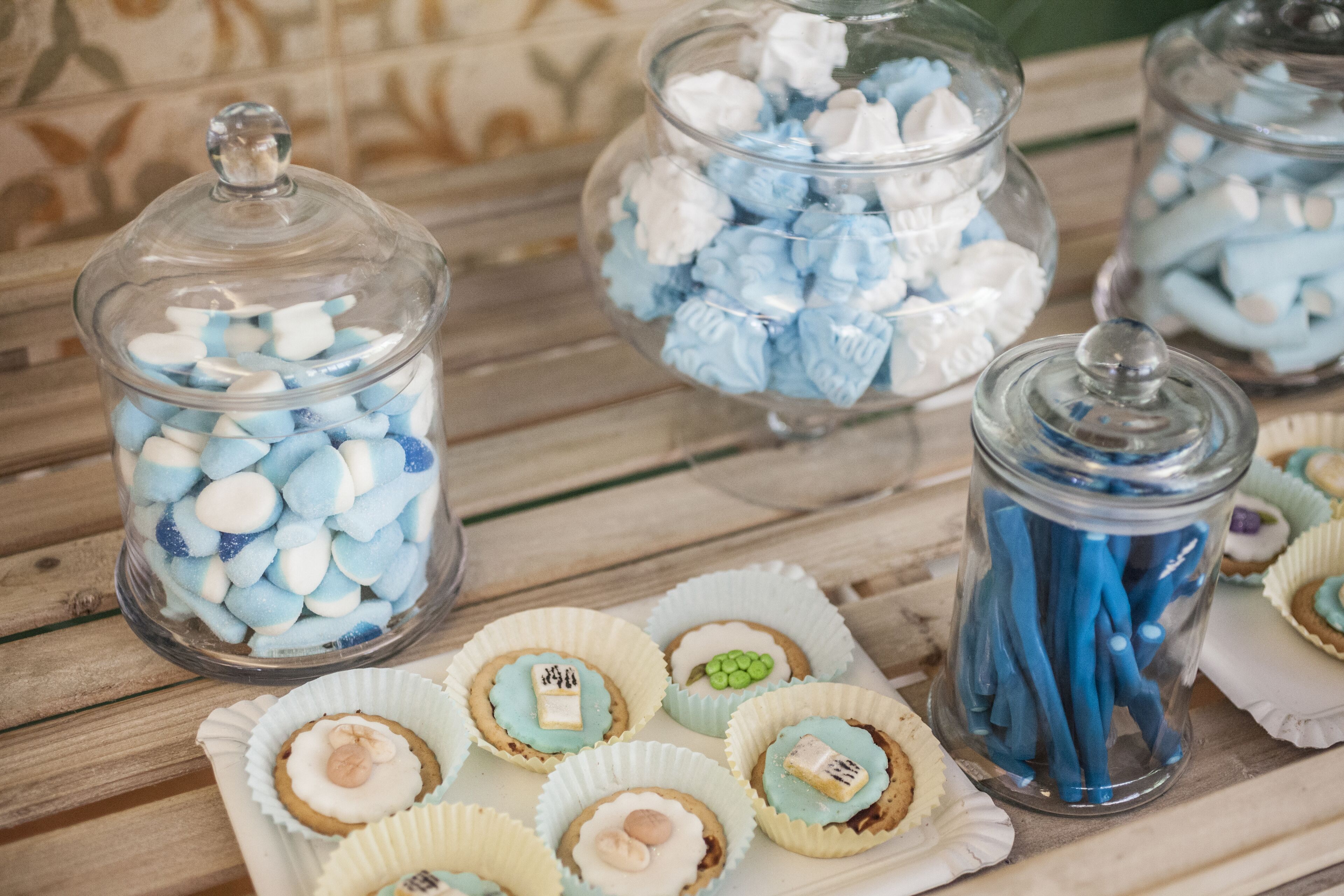 Une table avec des bocaux de bonbons et des biscuits décorés.