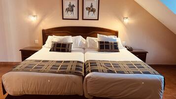A double bed with a wooden headboard, two bedside tables, and two framed pictures on the wall.