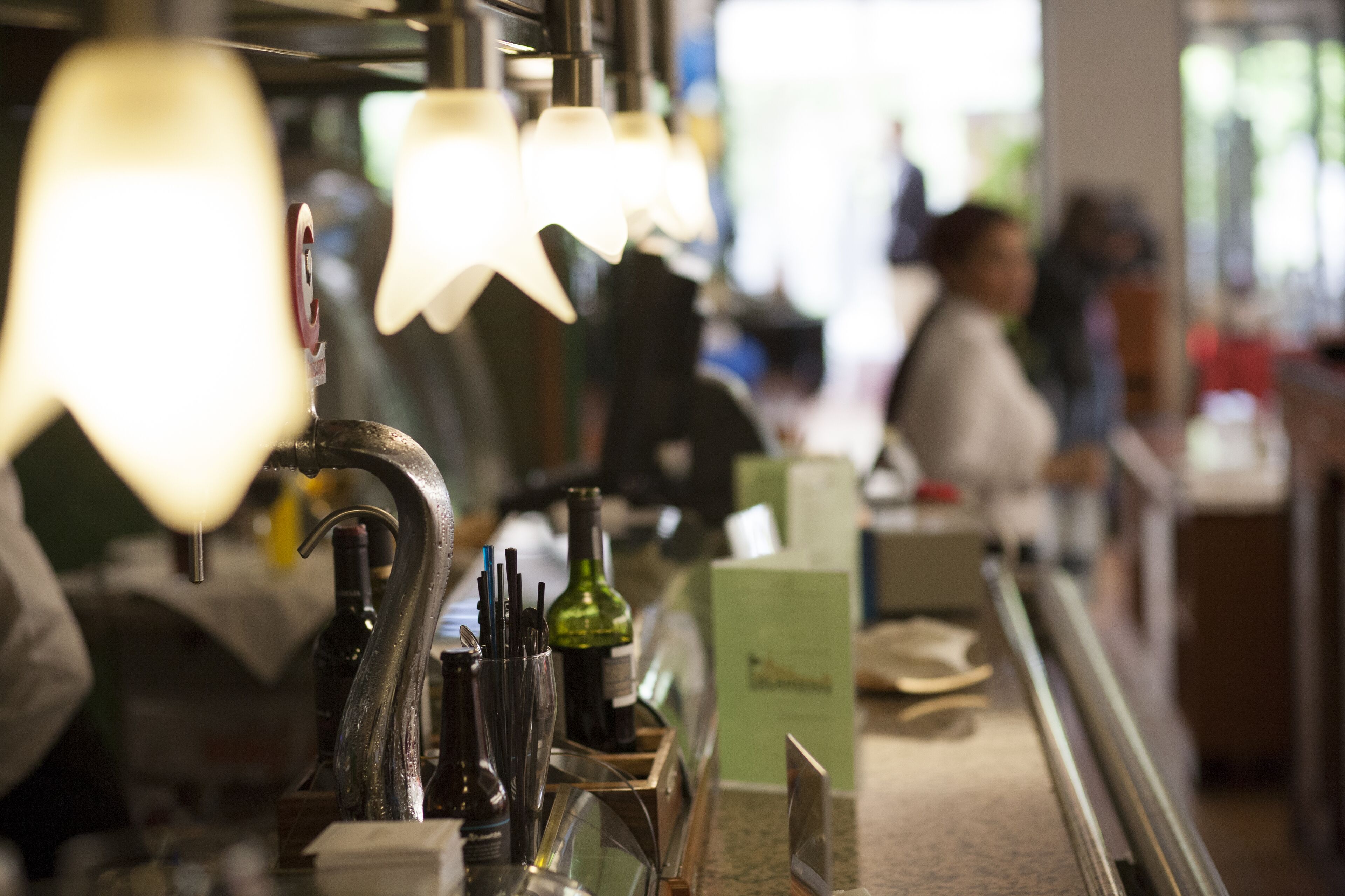 Eine Bar mit mehreren Lampen und einer Theke, auf der verschiedene Gegenstände liegen.