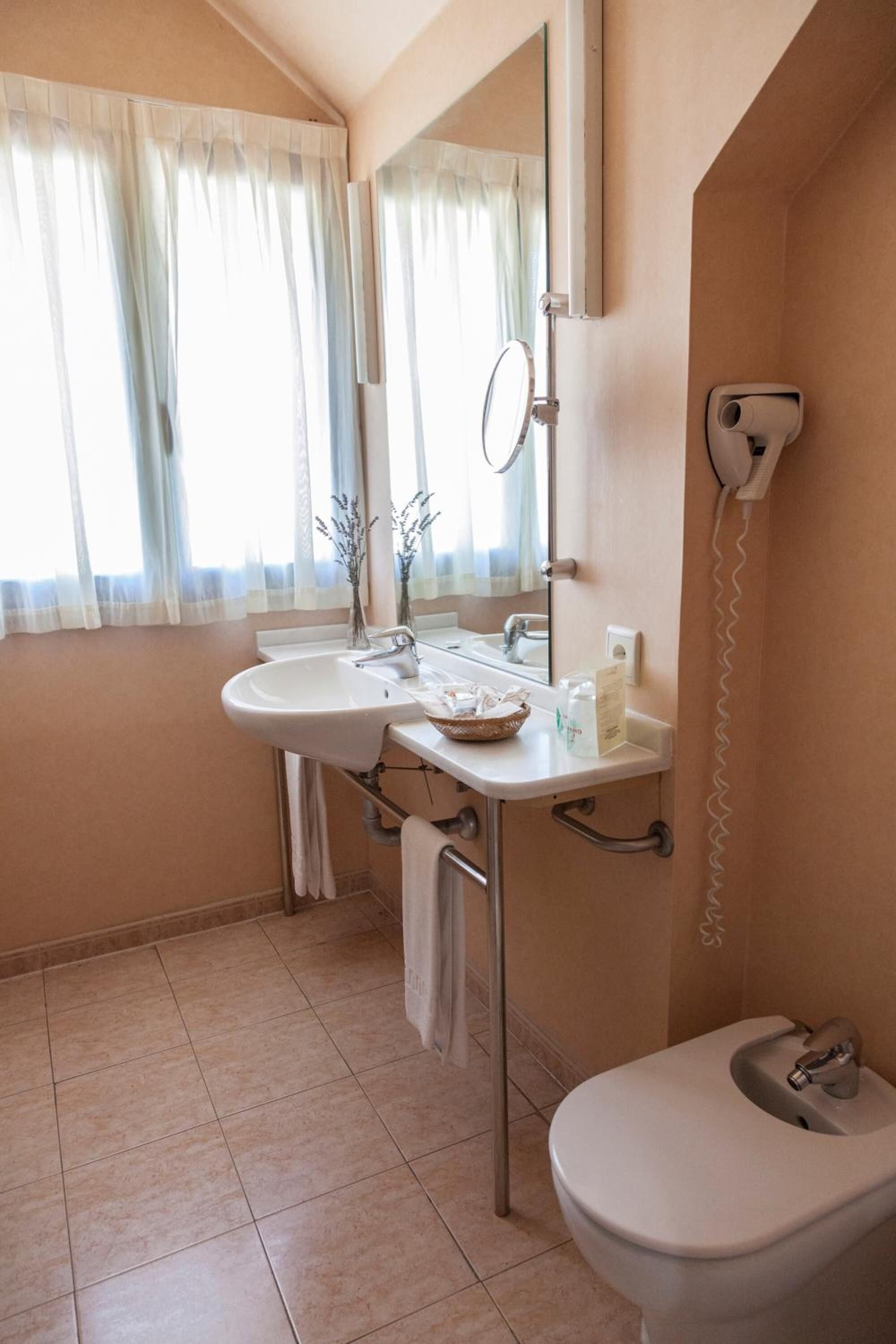 A bathroom with a sink, mirror, and toilet.