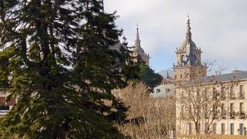 Un edificio con múltiples cúpulas y agujas, rodeado de árboles y un cielo despejado.