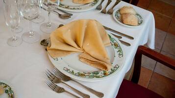 A table set for a meal with plates, cutlery, and wine glasses.