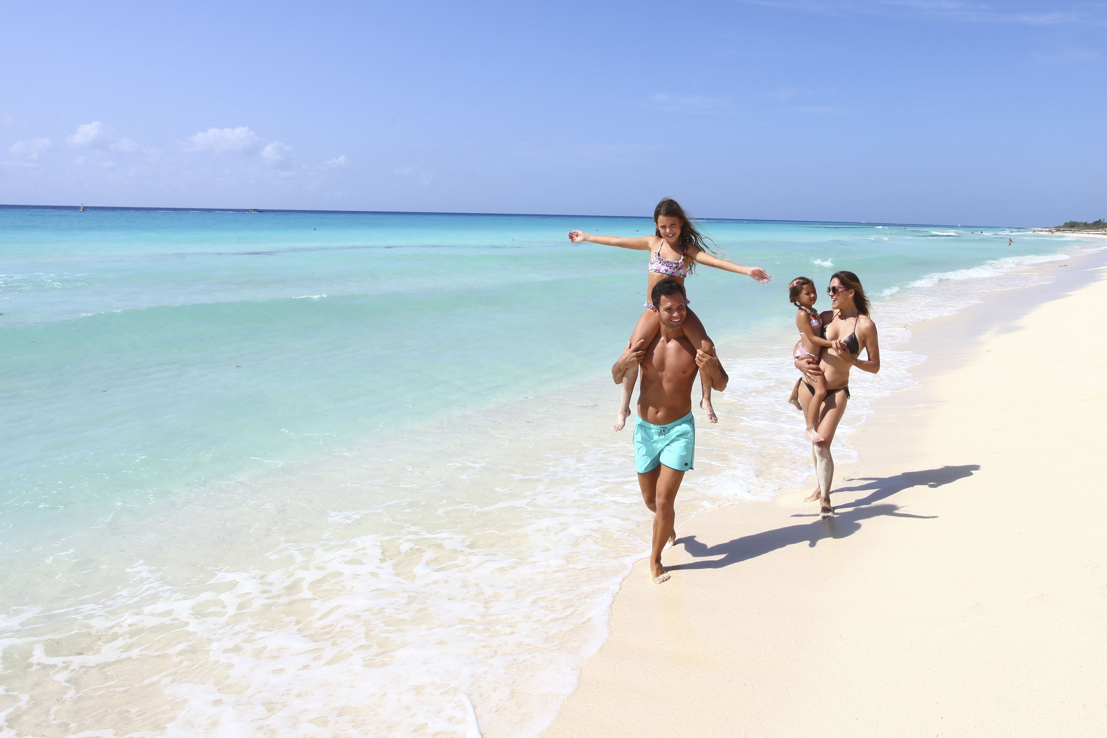 Escena de playa con agua turquesa cristalina y una orilla arenosa.