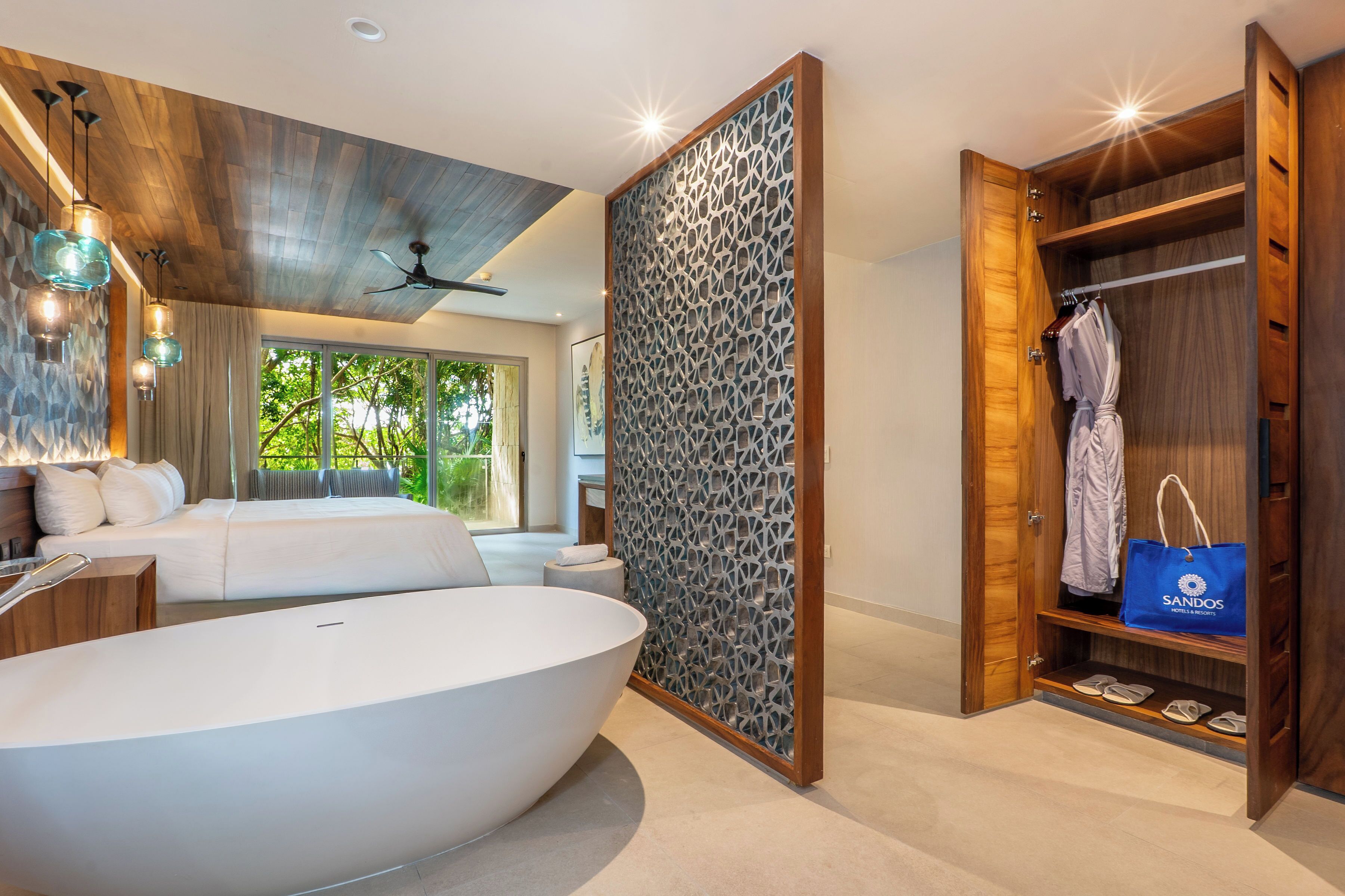 A modern bathroom with a large bathtub, a wooden ceiling, and a wardrobe with a blue bag.