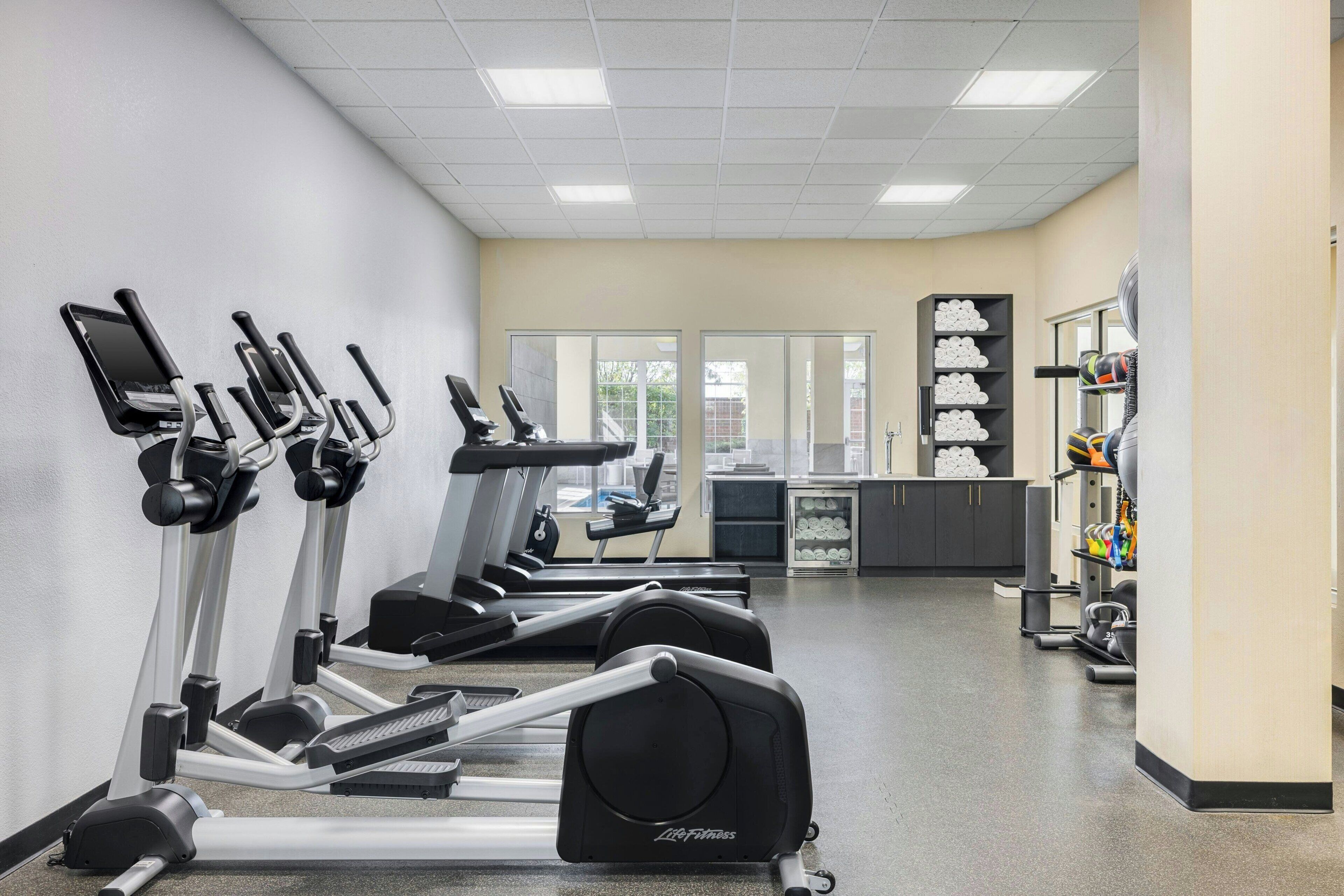 Ein Fitnessraum mit Laufbändern, einem Ergometer und einer Gewichtbank.