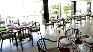 An outdoor dining area with tables and chairs, some with wine glasses and napkins. - Gran Plaza Hotel & Convention Center (Guanajuato)