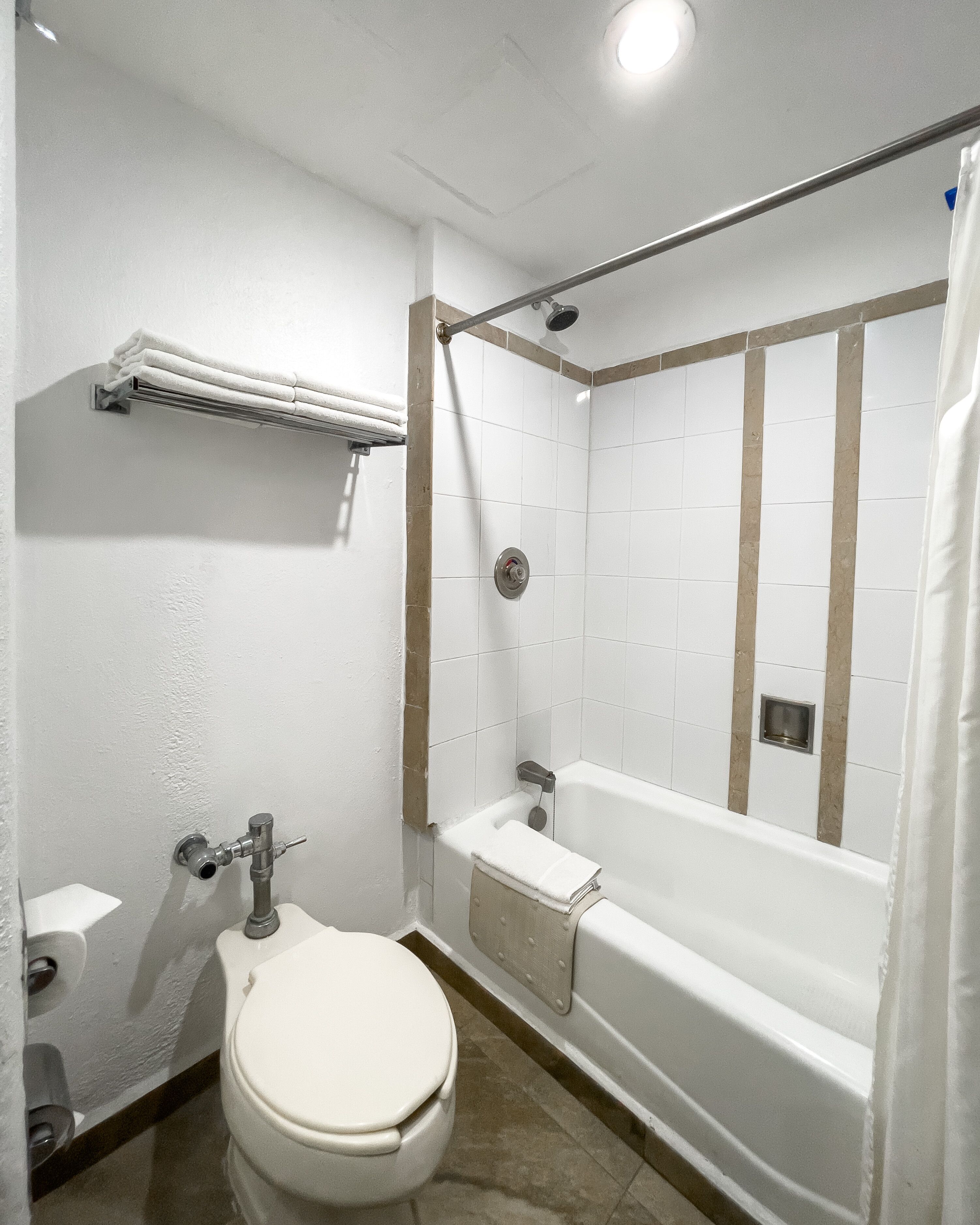 A bathroom with a toilet, a sink, and a bathtub with a shower curtain.