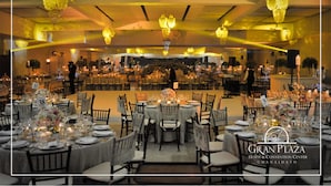 A banquet hall with round tables set for a formal event, featuring chandeliers and floral centerpieces. - Gran Plaza Hotel & Convention Center (Guanajuato)