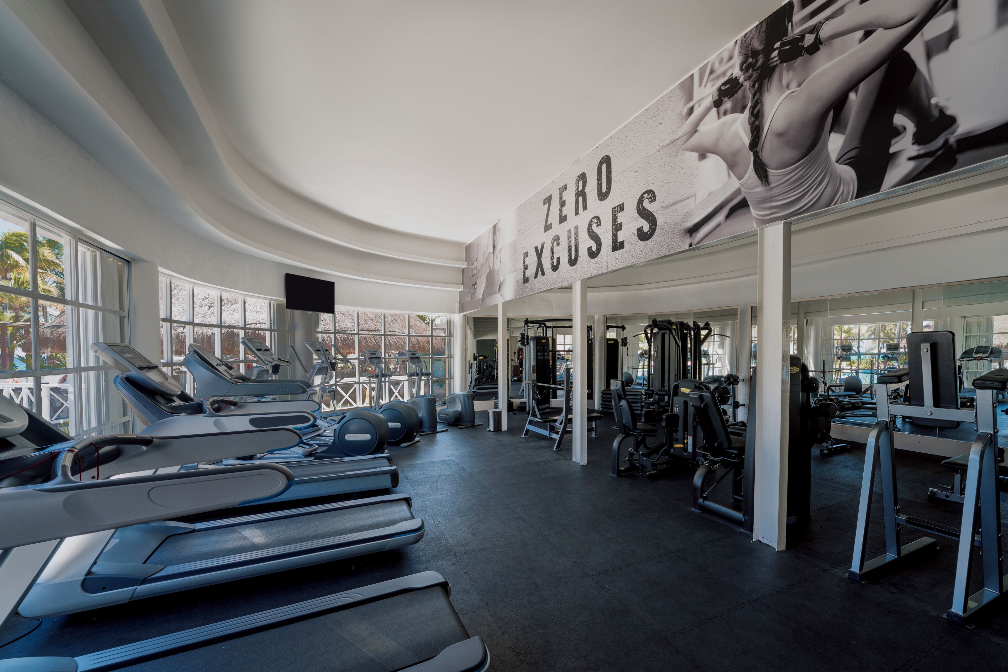 Un gimnasio con cintas de correr, pelotas de ejercicios y máquinas de pesas.