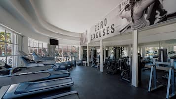 Un gimnasio con cintas de correr, pelotas de ejercicios y máquinas de pesas.