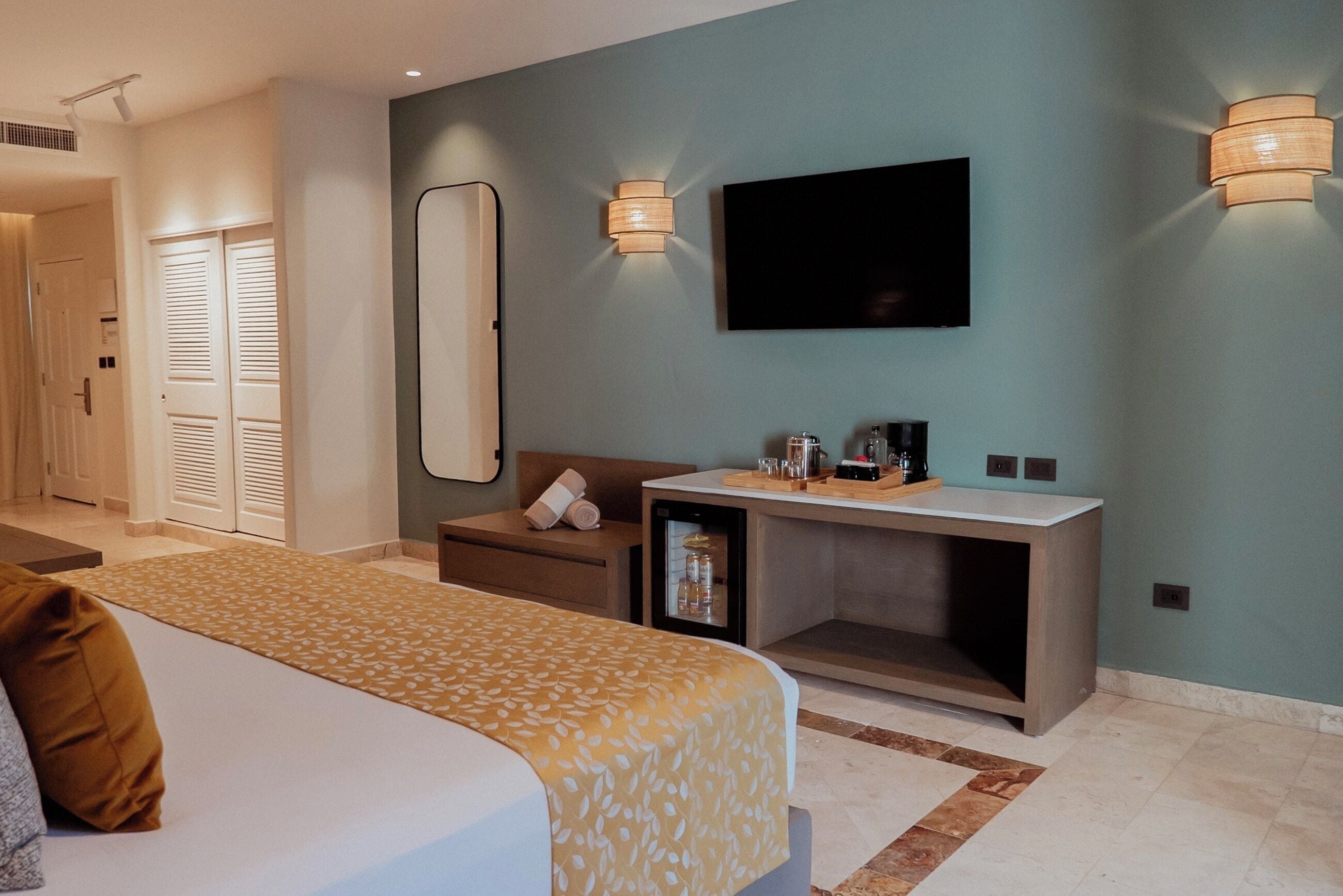 Ein Hotelzimmer mit Bett, Nachttisch, Fernseher und einer kleinen Sitzecke.