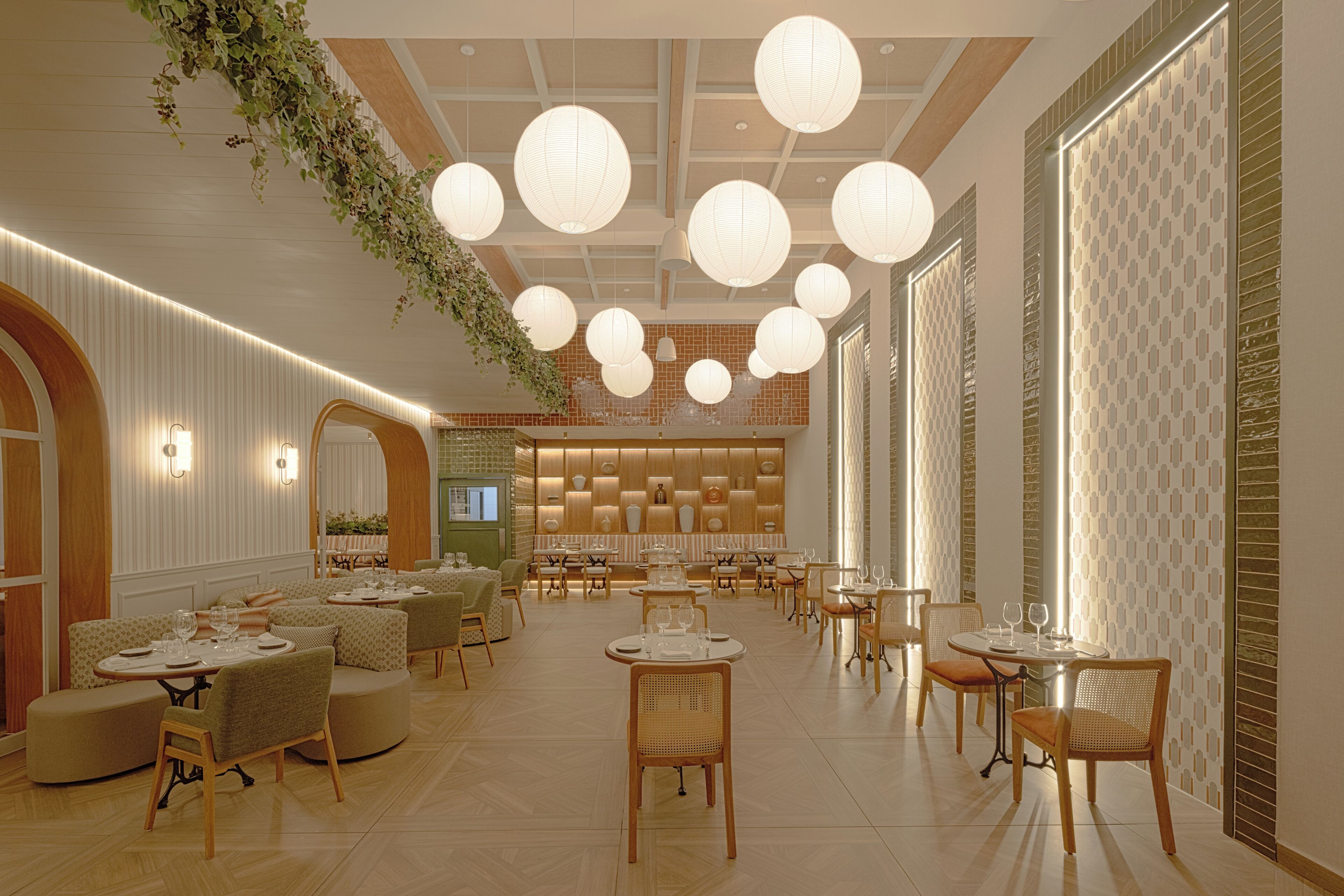 Ein geräumiges Restaurant mit verschiedenen Essbereichen, hängenden Laternen und vielfältigen Sitzmöglichkeiten.