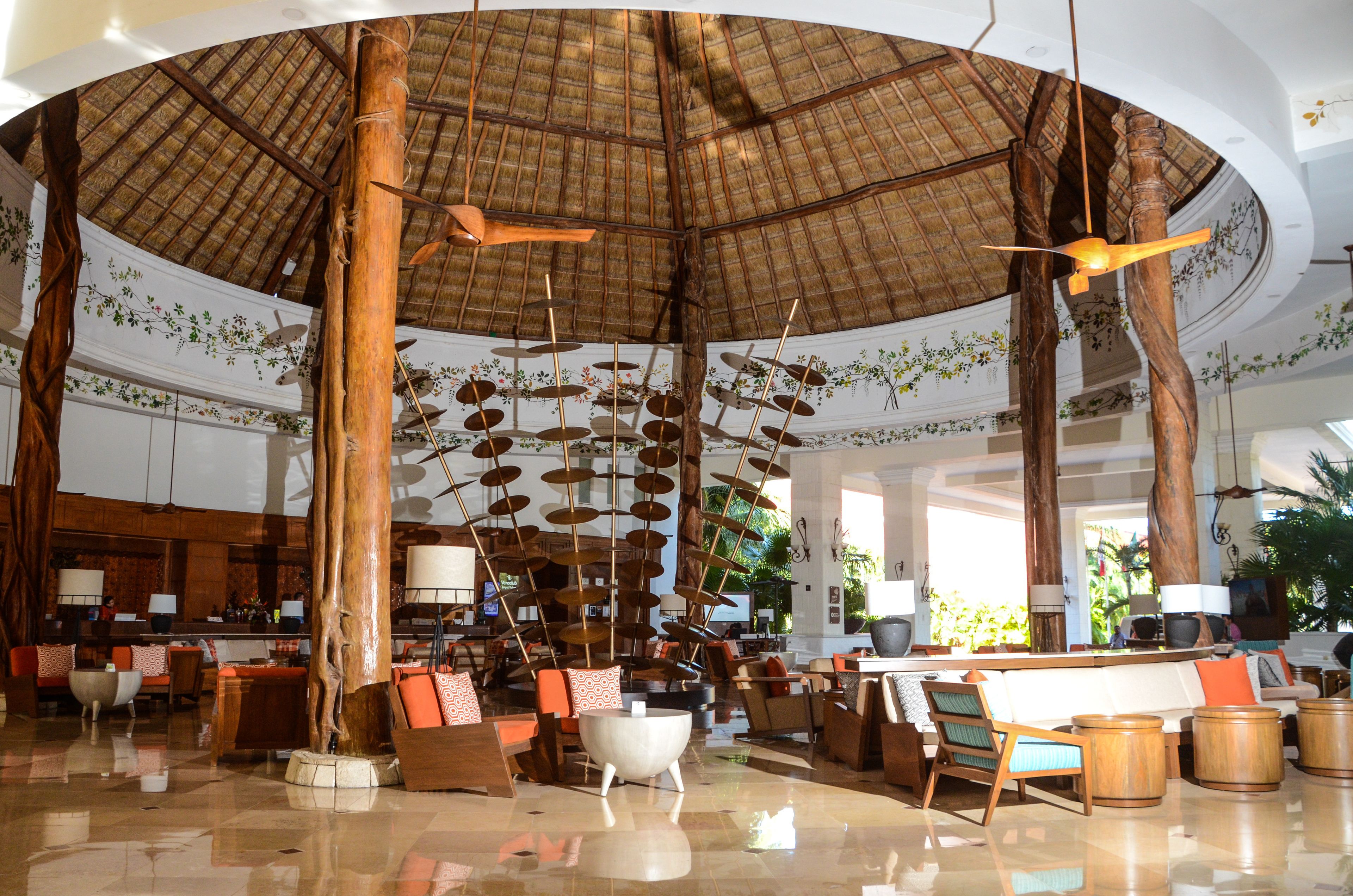 A spacious lobby with a high ceiling, wooden beams, and a central chandelier.