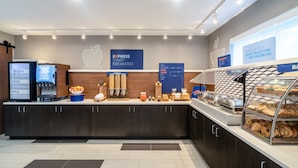 A modern breakfast area with a digital menu display, a variety of food options, and a clear sign for express breakfast. - Holiday Inn Express Bluffton at Hilton Head Area by IHG (Bluffton)