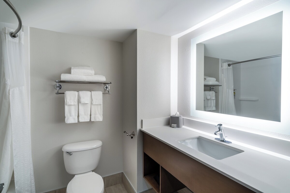 Une salle de bain moderne avec des toilettes, un lavabo et un miroir.