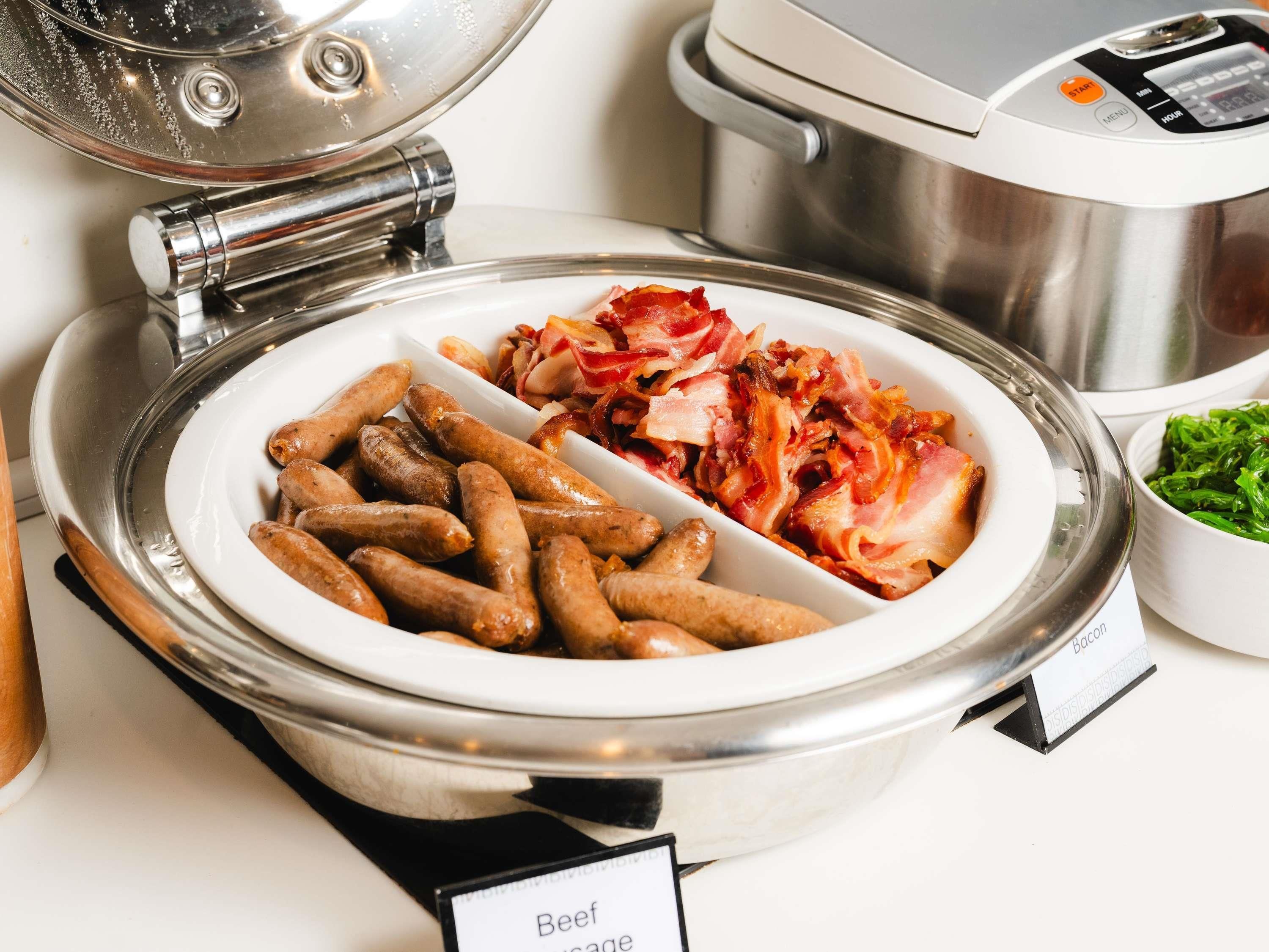A buffet with a sign indicating 'Beef Sausage' and 'Bacon'.