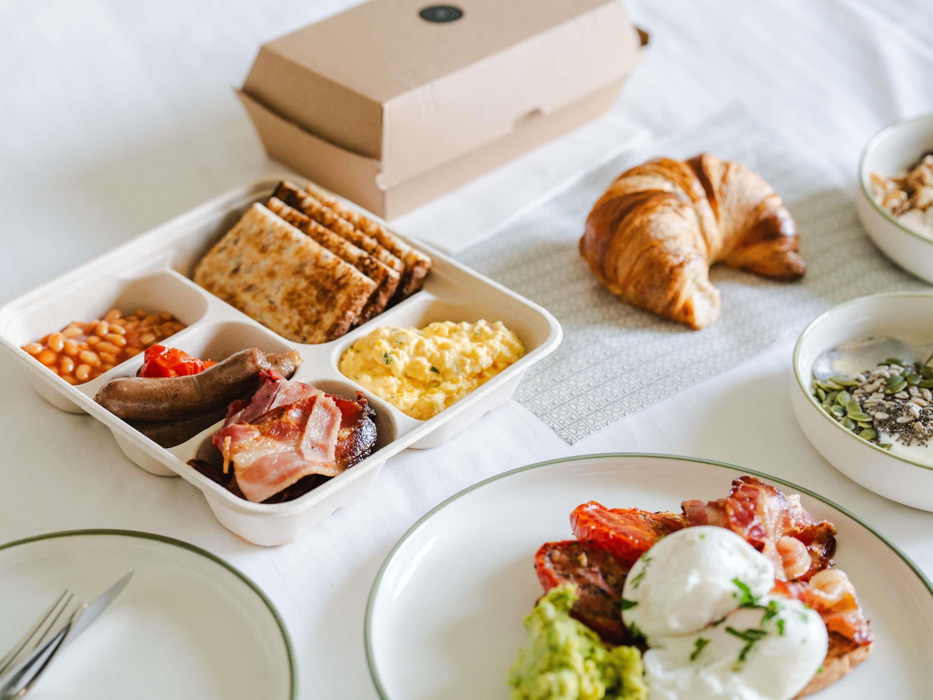 A breakfast tray with various foods including sausages, beans, scrambled eggs, and toast.