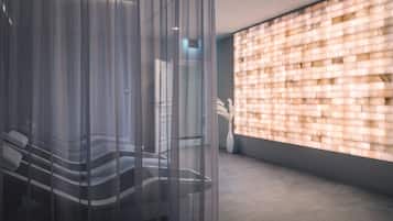 A modern interior with a glass partition, a brick-patterned wall, and a tiled floor.