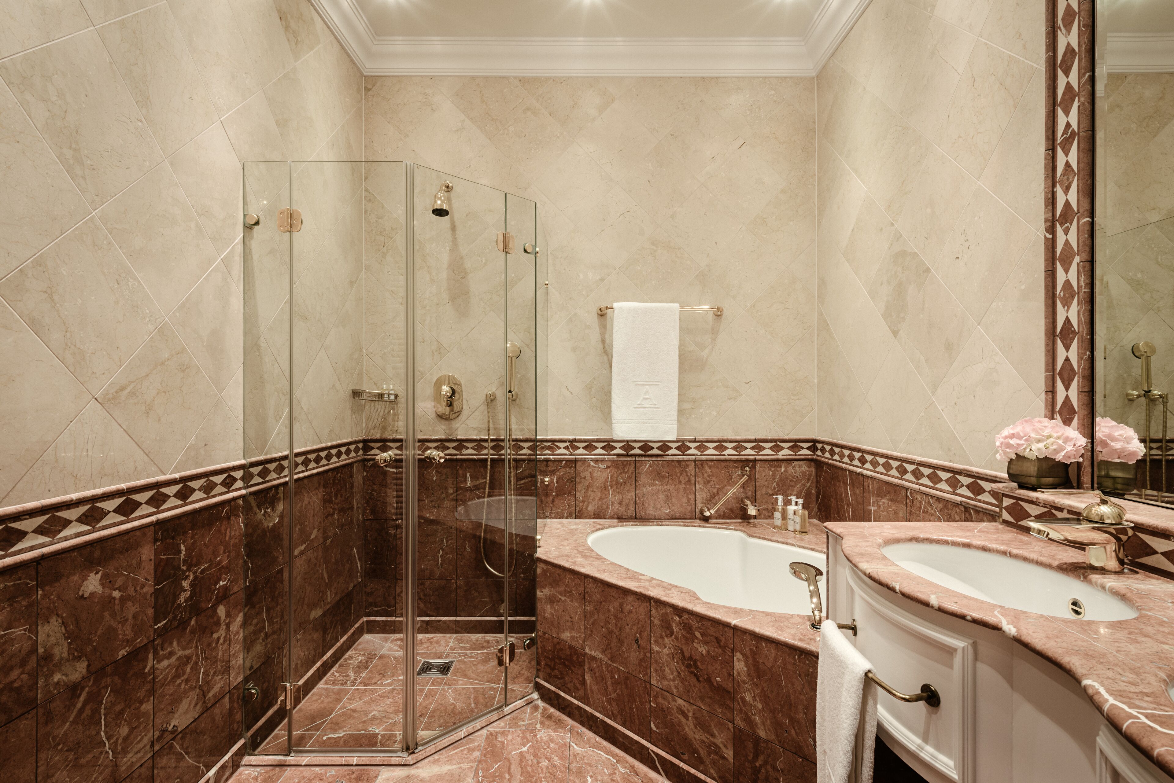 A modern bathroom with a glass-enclosed shower, a freestanding bathtub, and a vanity with a mirror.