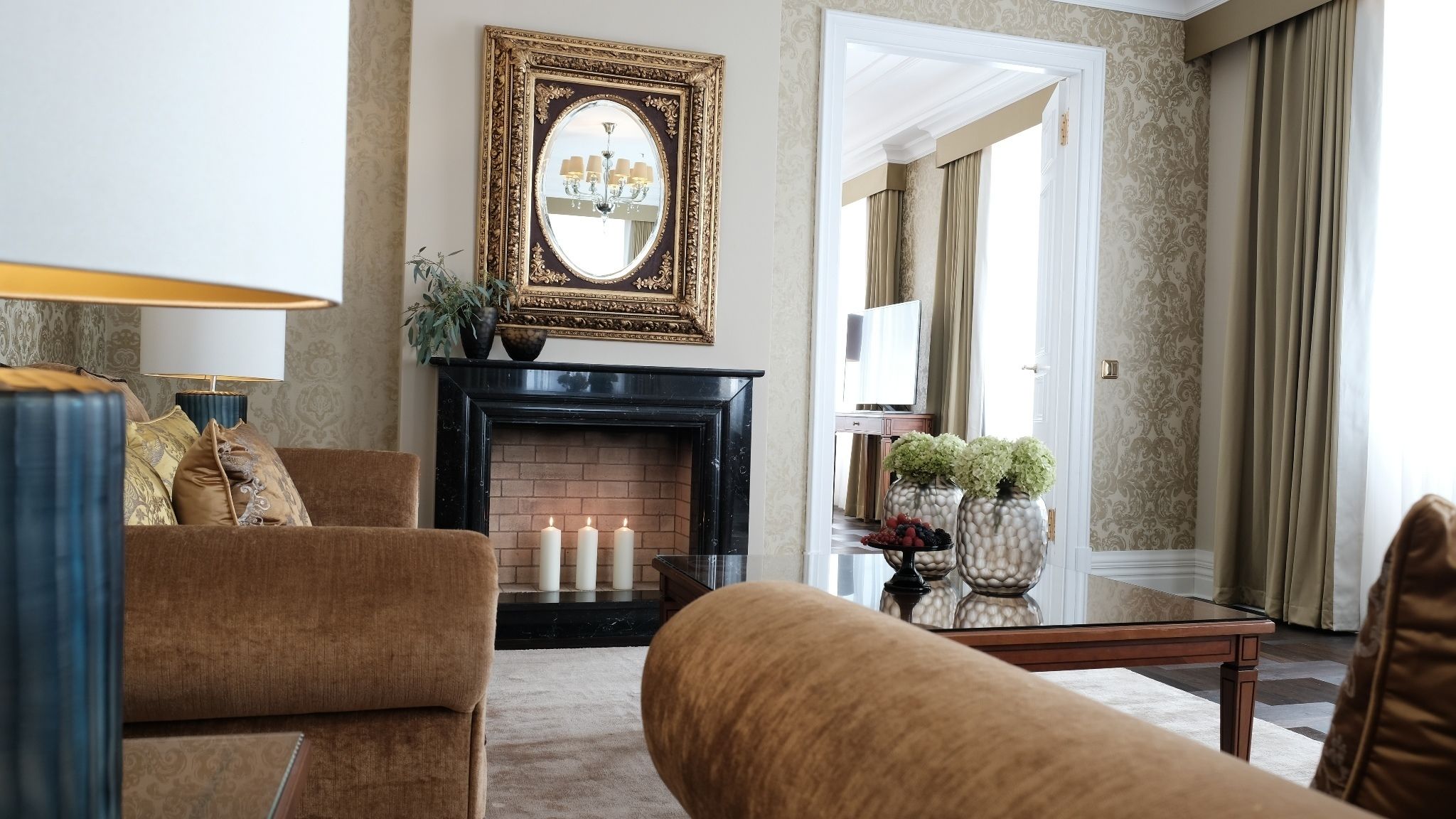 A living room with a fireplace, two sofas, a coffee table, and a mirror.