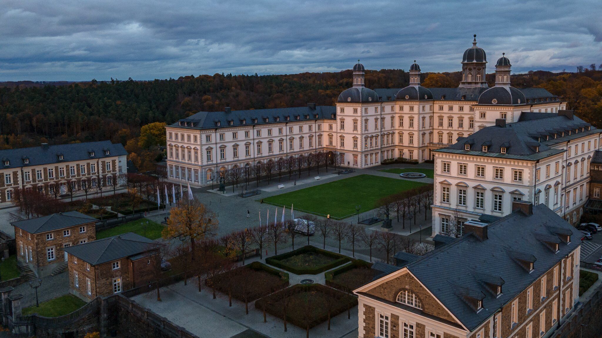 Un grande edificio storico con più ali e un cortile centrale.