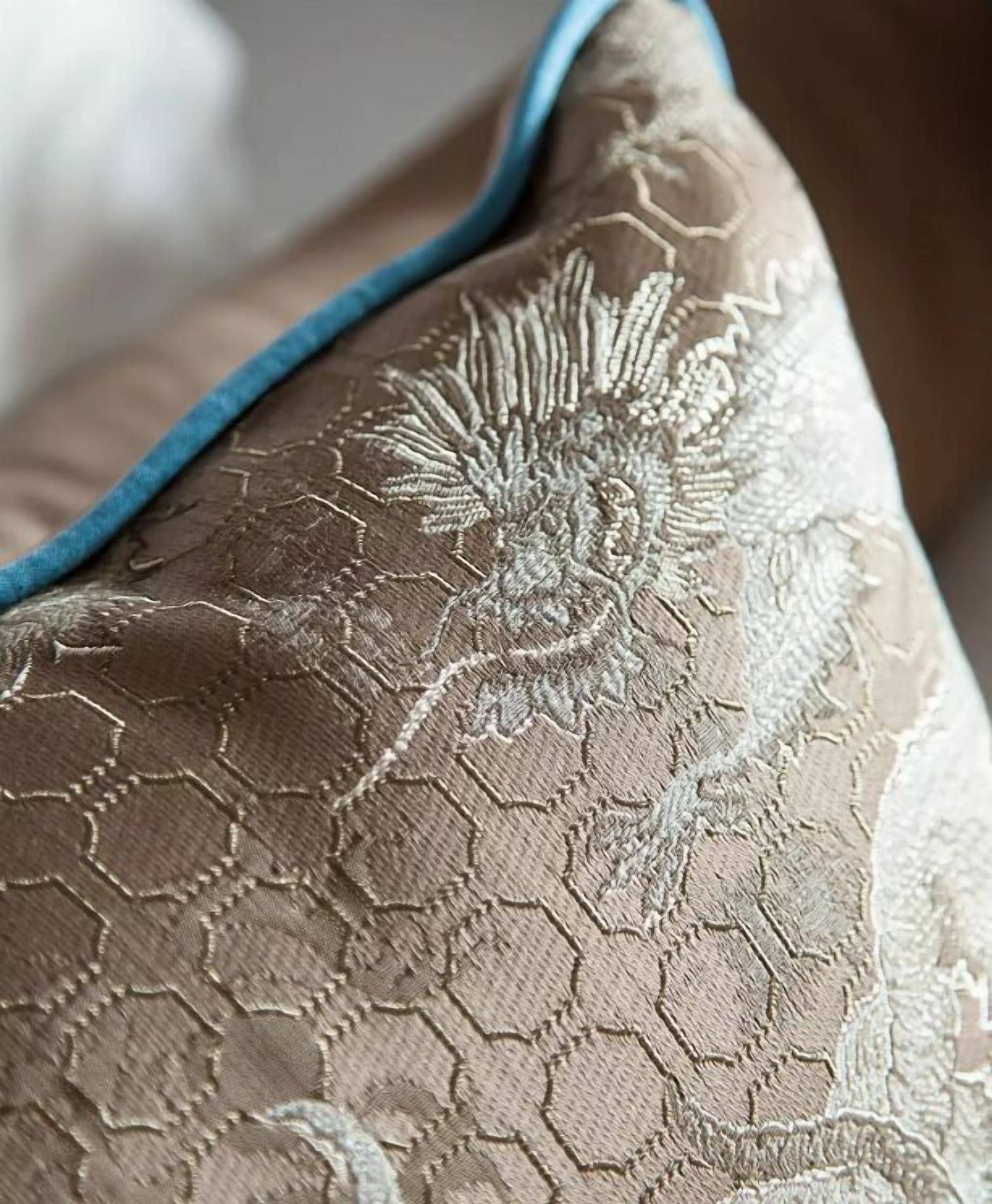 A close-up of a pillow with a textured pattern and a blue trim.