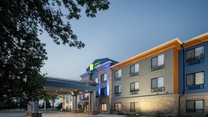 Ein mehrstöckiges Hotel mit flachem Dach, großen Fenstern und einem gut beleuchteten Eingang.