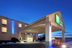 Een Holiday Inn Express gebouw met een overdekte ingang en een zichtbare parkeerplaats.
