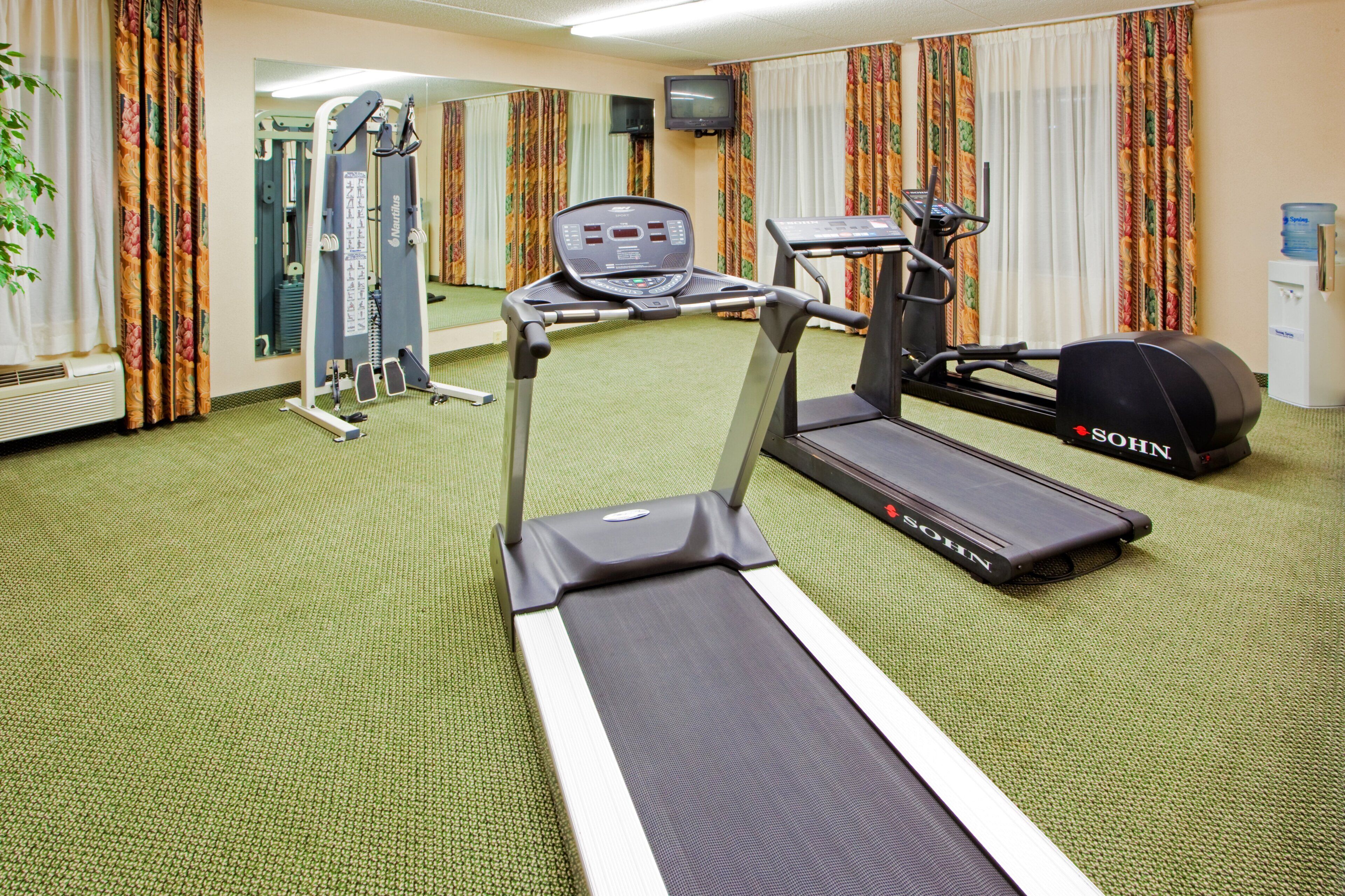 Ein Fitnessraum im Hotel mit Laufband, Ergometer und Krafttrainingsgeräten.