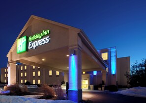 A Holiday Inn Express building with a prominent sign, a covered entrance, and a snow-covered ground. - Holiday Inn Express Hanover by IHG (Hanover)