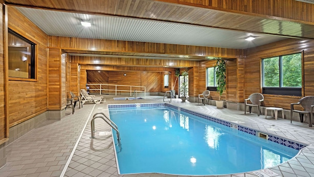 Una piscina interior con paredes de madera y suelo de baldosas.
