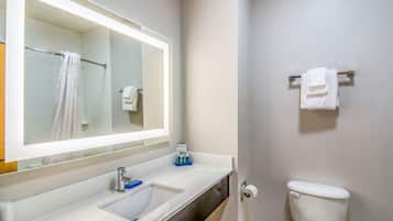 A bathroom with a sink, mirror, towel rack, and toilet.