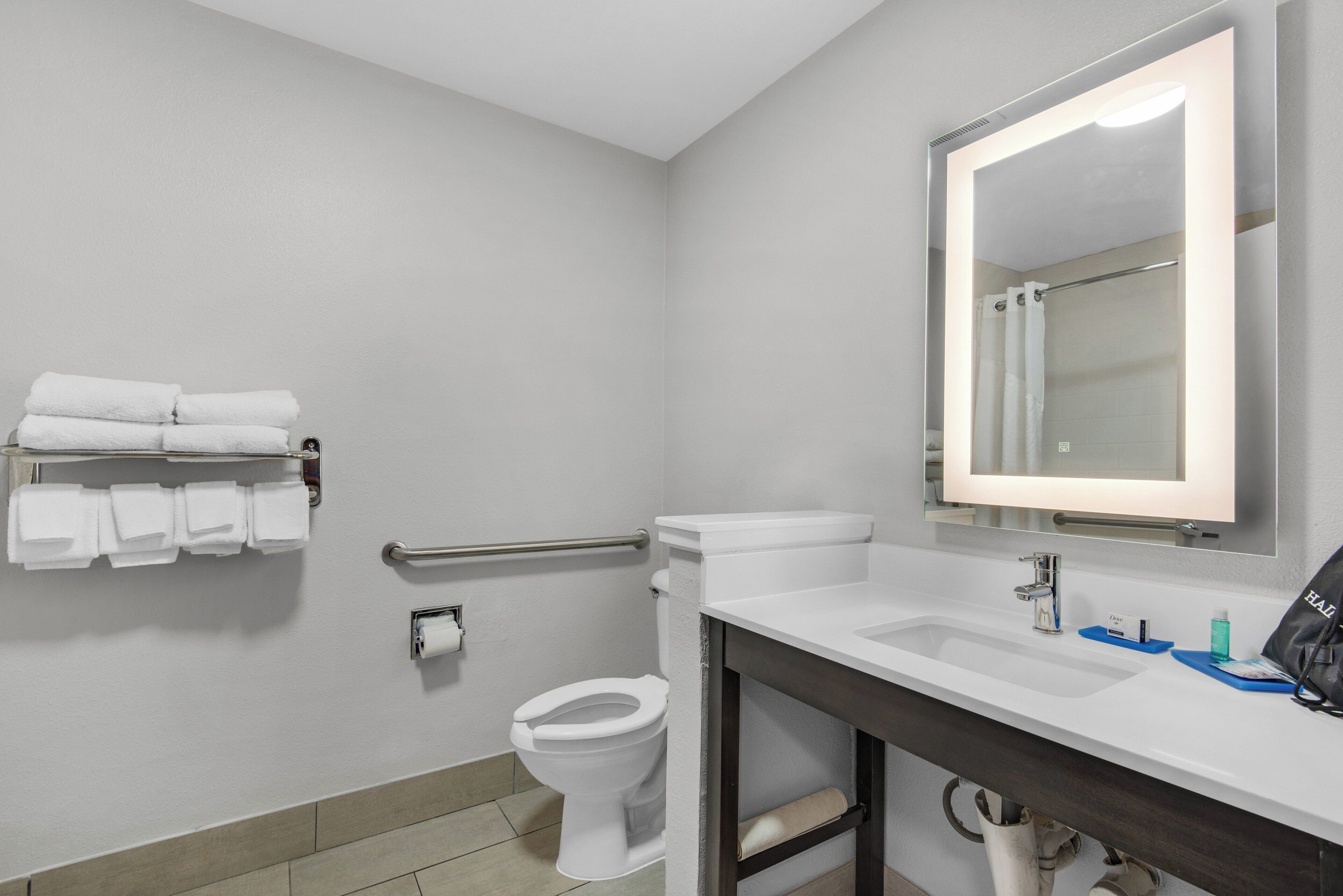 A modern bathroom with a toilet, sink, and a mirror.