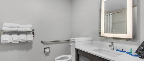 A modern bathroom with a toilet, sink, and a mirror.