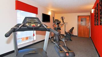 Une salle de sport équipée de tapis de course, d’un vélo elliptique et d’un vélo d’appartement.