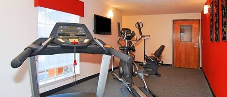 A gym with treadmills, an elliptical, and a stationary bike.