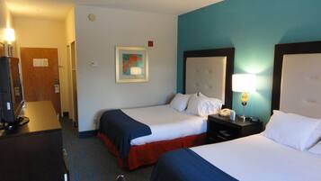 A hotel room with two beds, a desk, a chair, a TV, and a painting on the wall.
