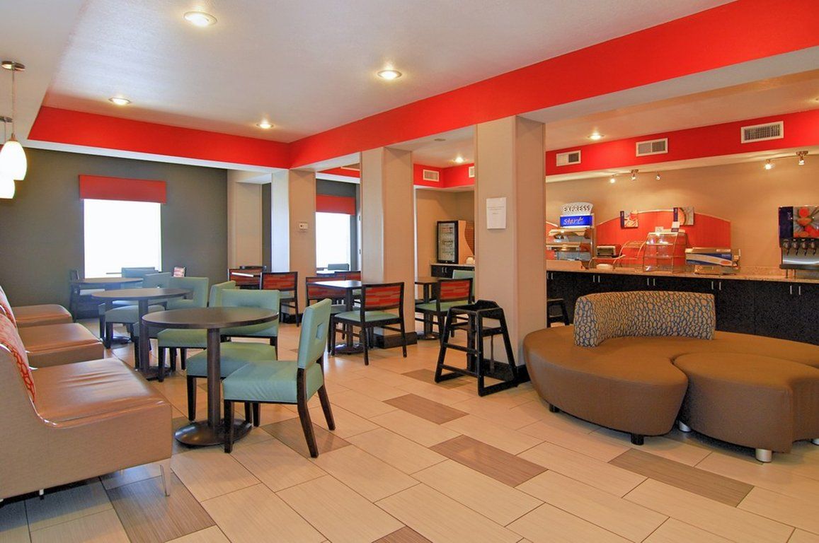 A hotel lobby with seating areas, a reception desk, and a counter with a coffee machine.