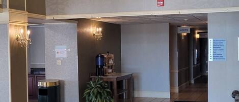 A spacious lobby with a large chandelier, a patterned carpet, and a view of the upper floor.