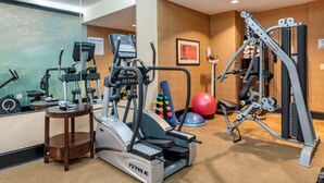 A gym with cardio machines, weightlifting equipment, and a mirror. - BW Plus Flagler Beach Area Inn & Suites (Palm Coast)