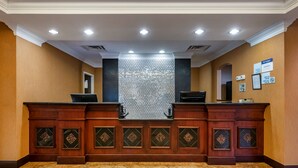 A reception area with a check-in counter, a decorative wall, and a tiled floor. - BW Plus Flagler Beach Area Inn & Suites (Palm Coast)