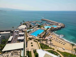 A resort with multiple swimming pools, a beach, and a marina.