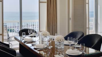 A dining table set for four with a view of the ocean.