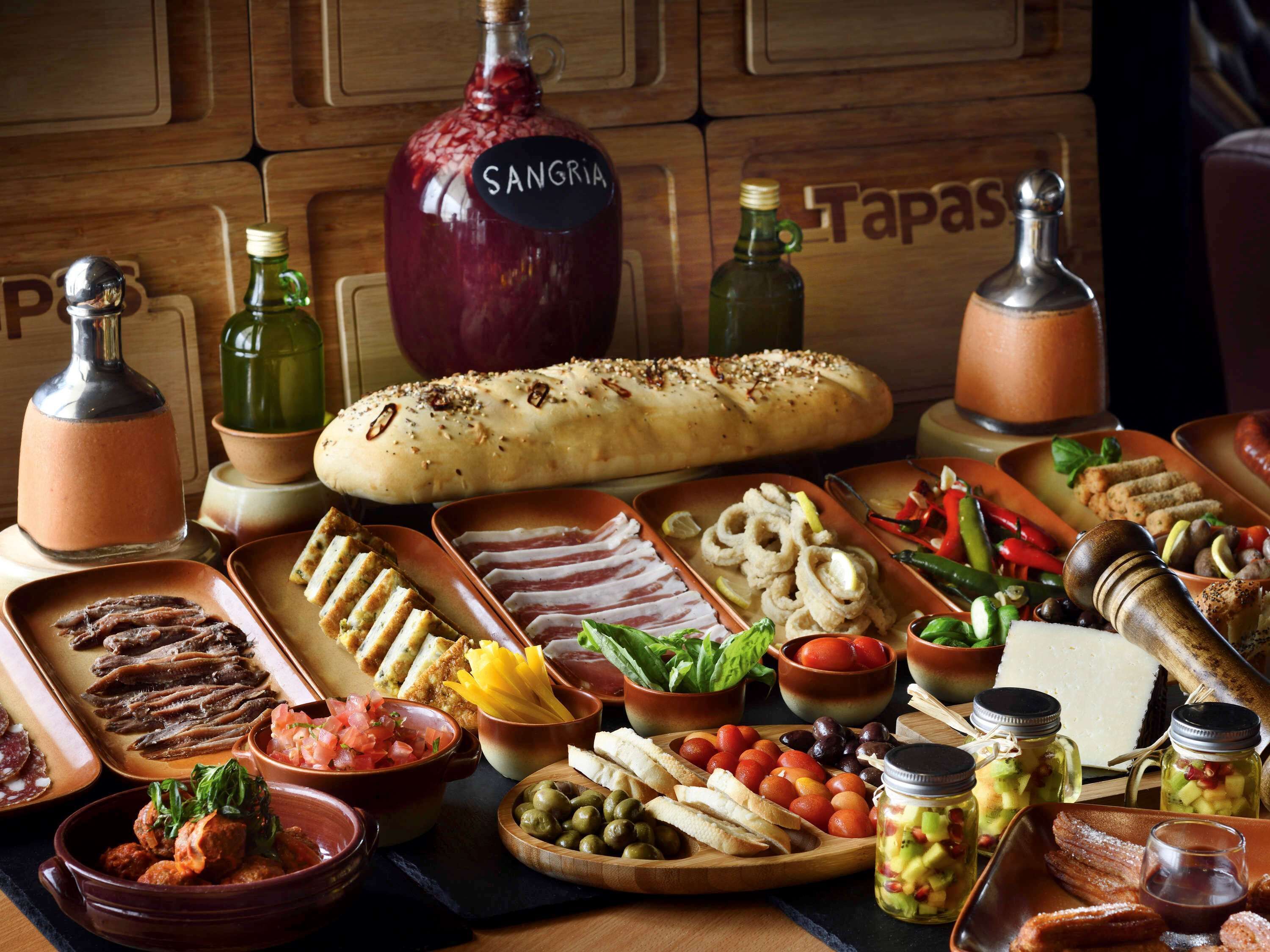 A variety of food items including bread, cured meats, olives, and cheese, suggesting a culinary setting.