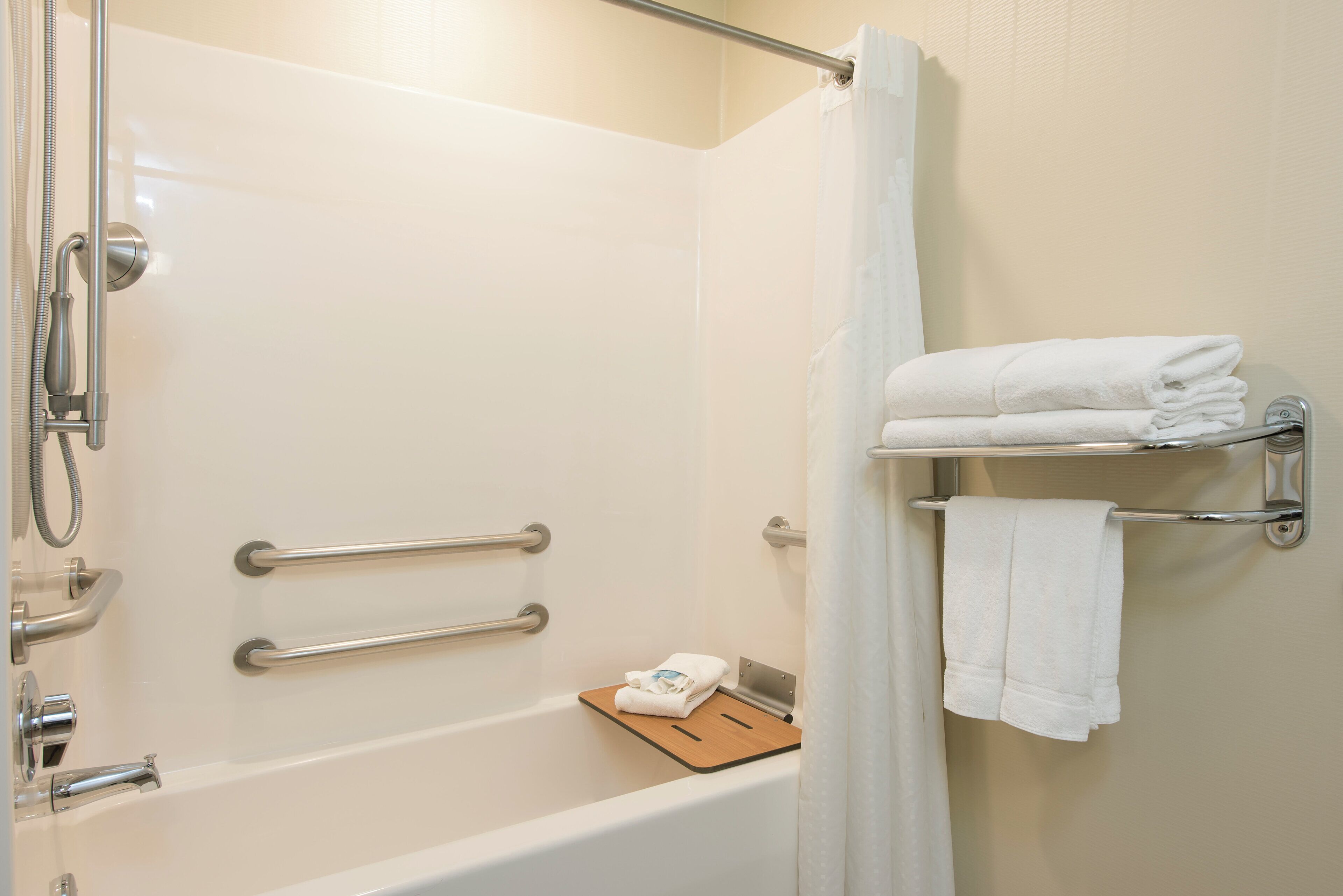 A bathroom with a bathtub, a shower, and a towel rack.