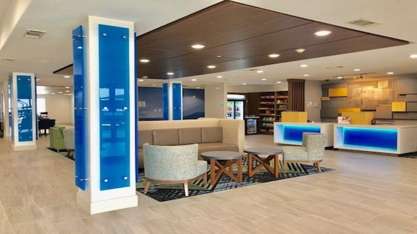 Um hall moderno com balcão de recepção, área de estar e escada.