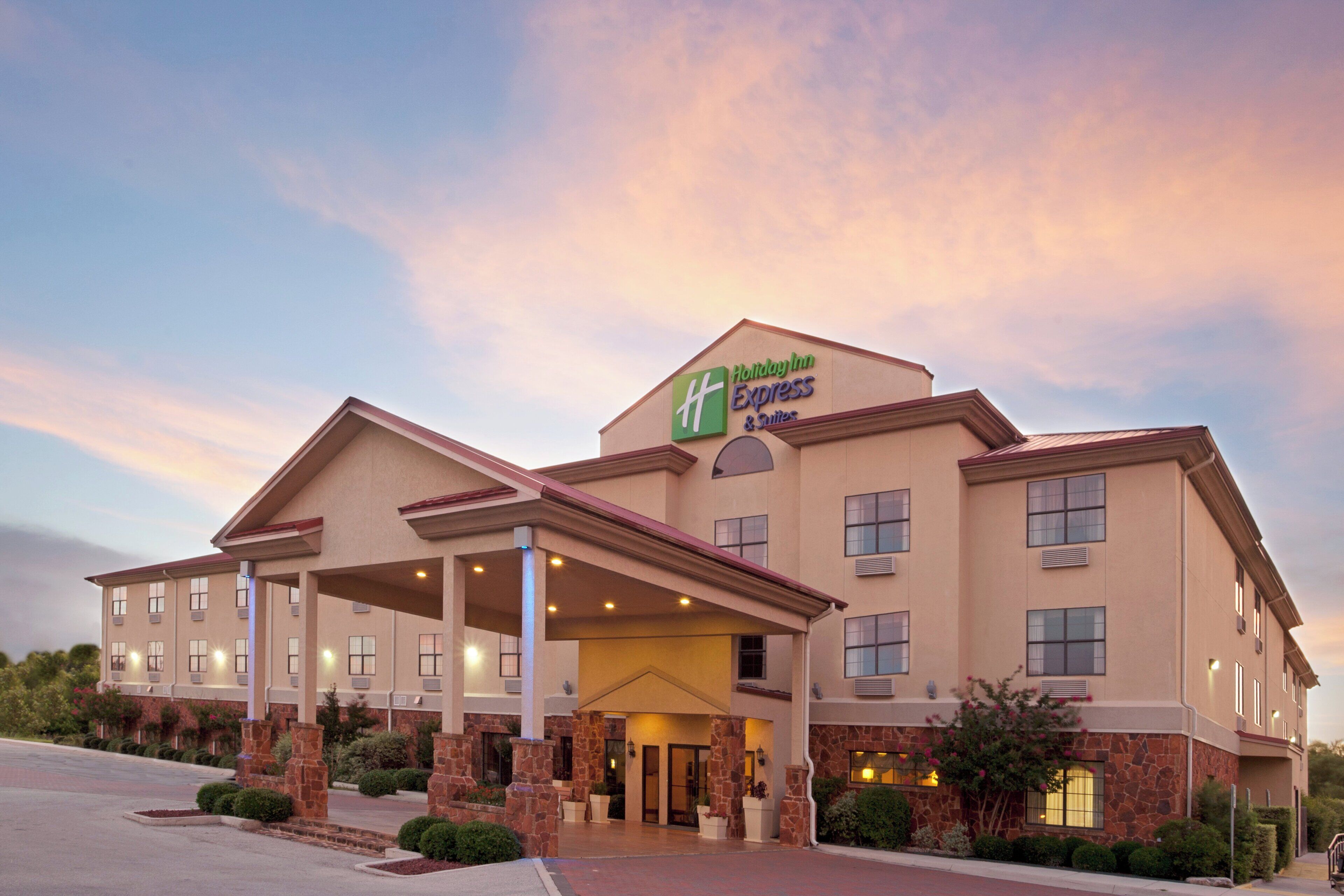 Edificio Holiday Inn Express con entrada cubierta, varias ventanas y fachada de piedra.
