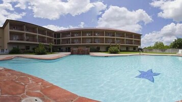 Un hotel con piscina que presenta un diseño en forma de estrella en el agua.